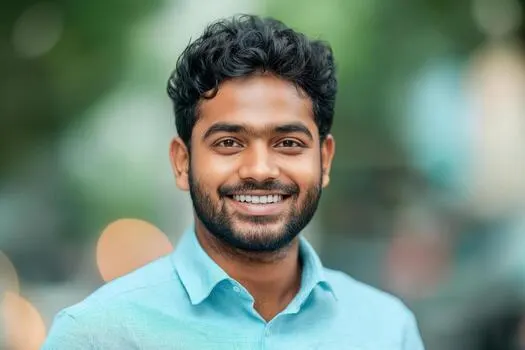 a smiling young indian man with formal shirts outdoors photo